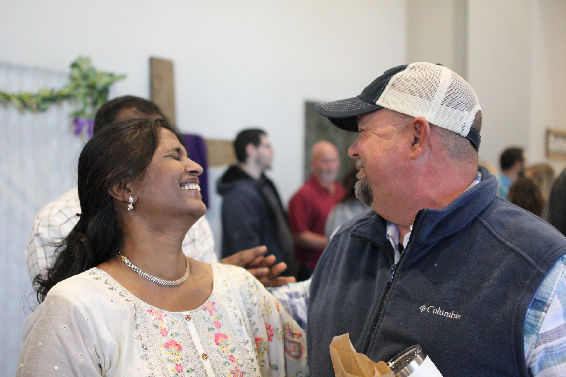 A man and a woman are laughing together in a room.