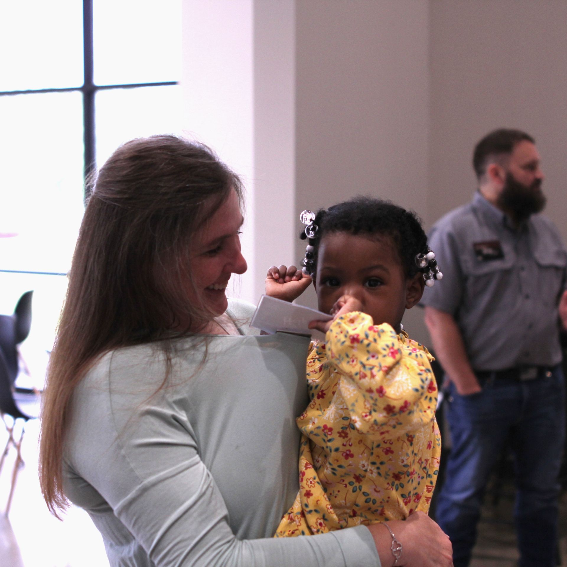 A woman is holding a little girl in her arms