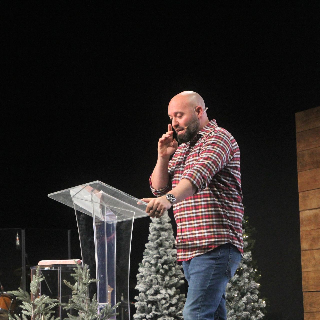 A man standing at a podium talking on a cell phone