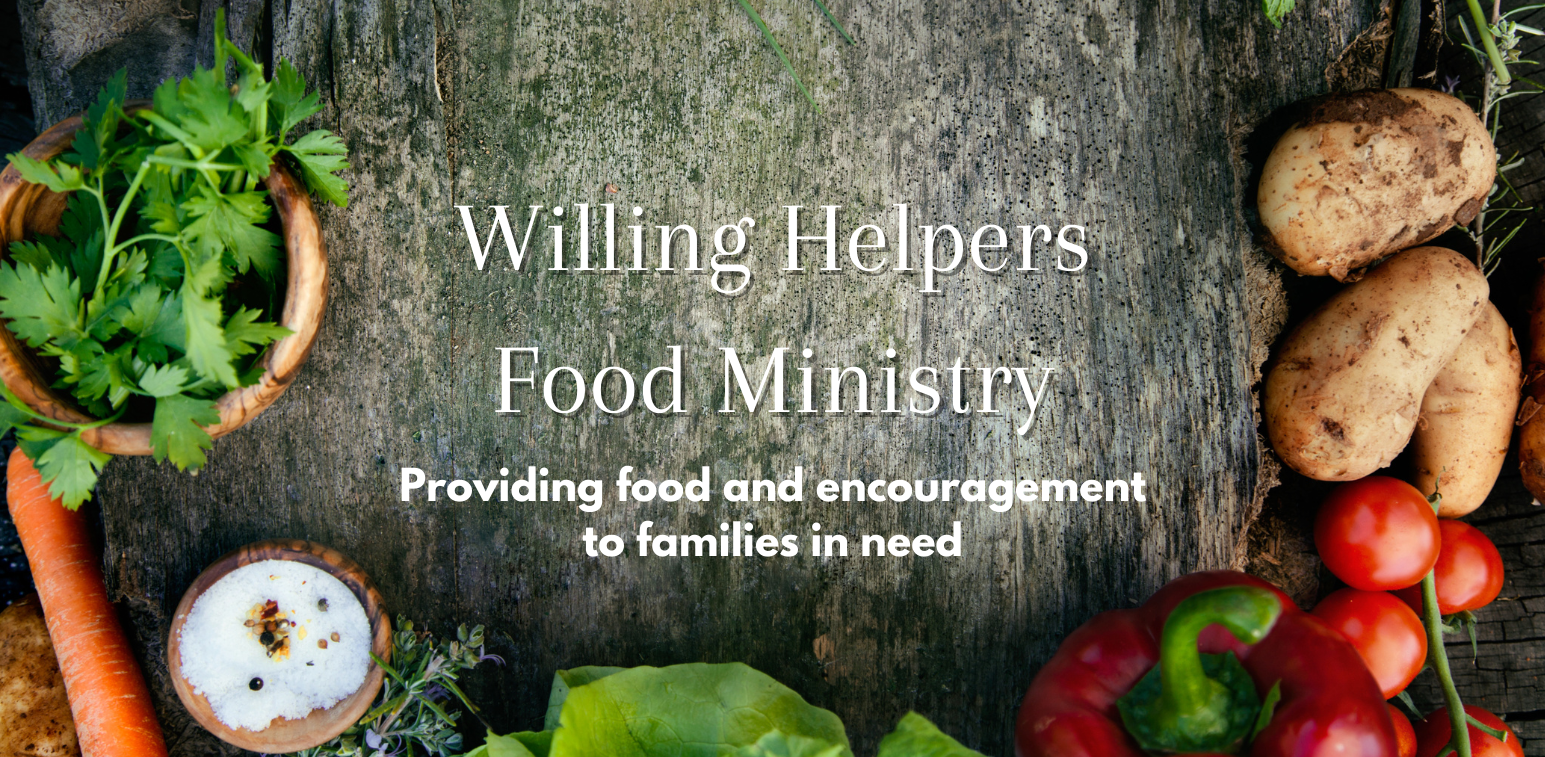 A wooden table topped with vegetables and herbs and the words `` willing helpers food ministry ''.