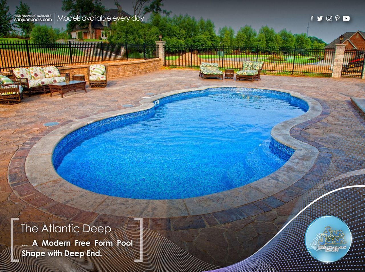 Modern free-form pool with blue water, stone deck, lounge chairs, and umbrella seating in a garden setting