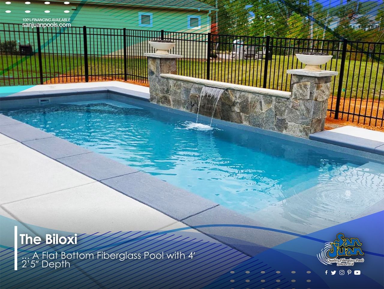 Backyard-style lap pool with blue water, stone waterfall wall, black fence, and green lawn