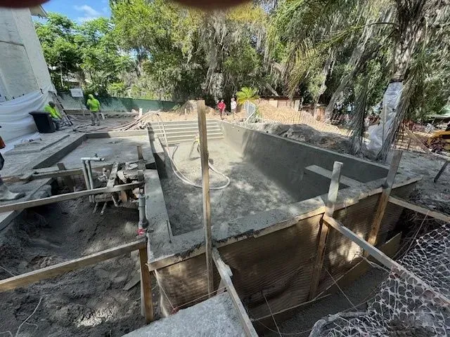 Concrete foundation under construction with wooden forms and scaffolding in a backyard outdoors