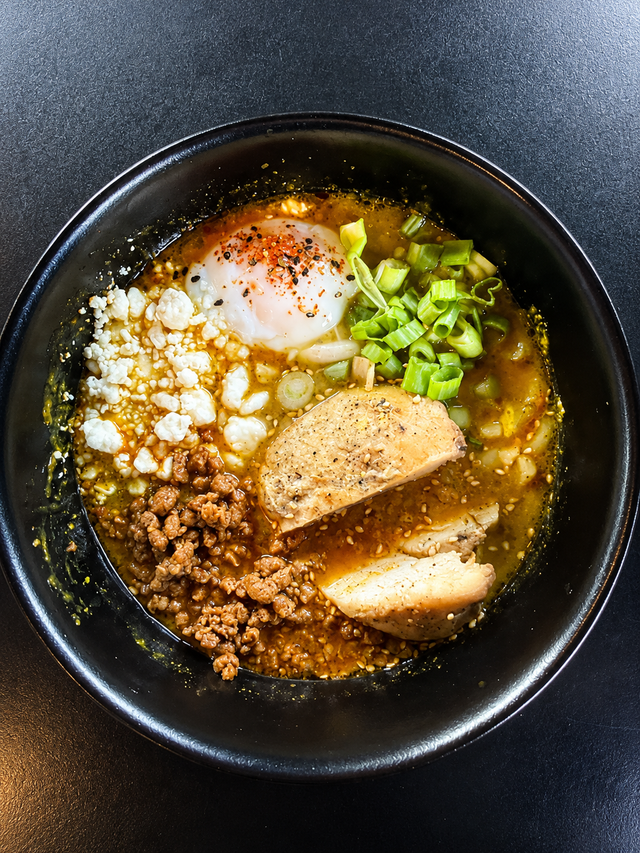 Chicken Chorizo Udon bowl with thick noodles, ground chorizo, green onion, and goat cheese