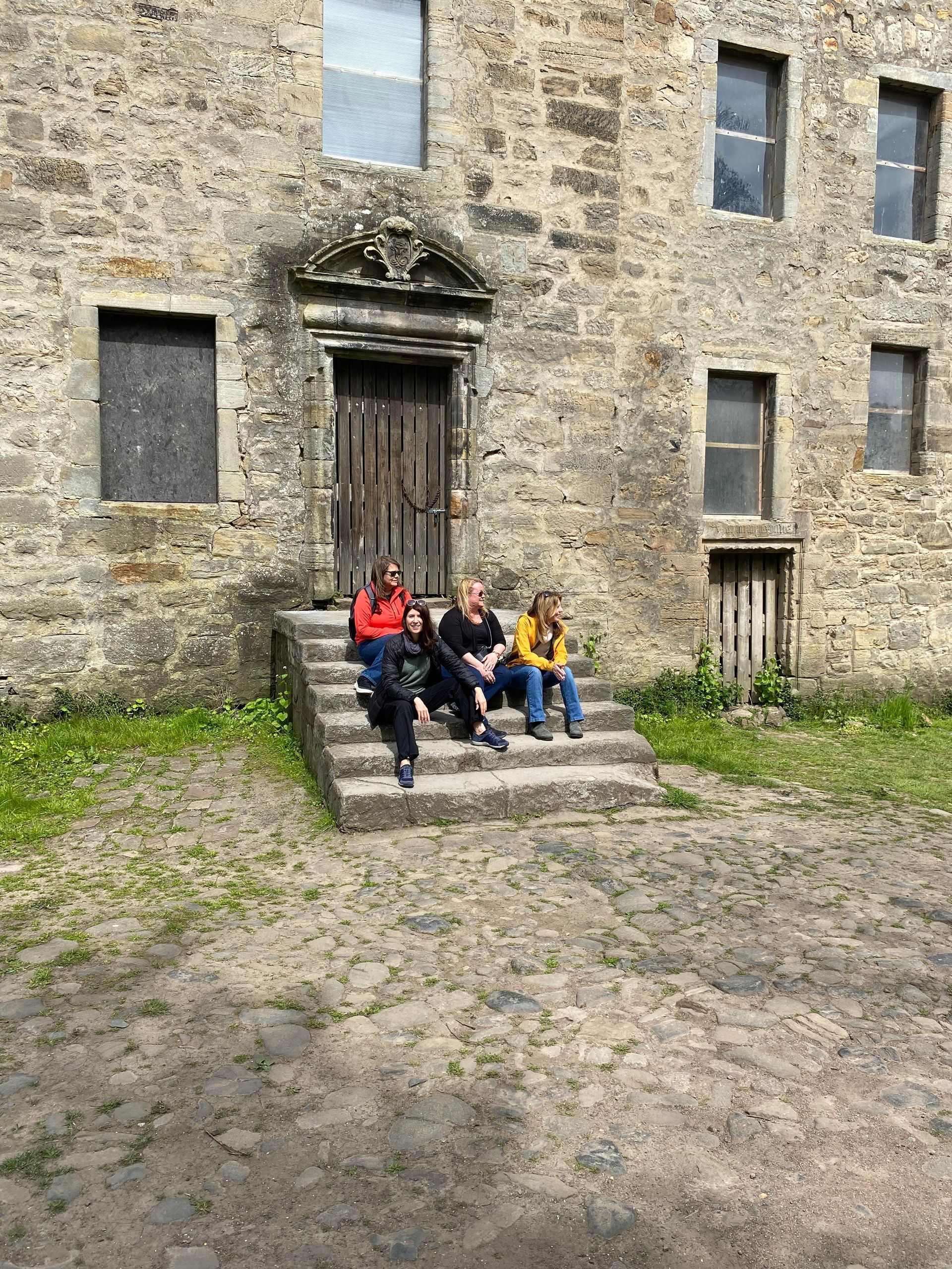 Our group sitting on the stairs of Lallybroch on our Outlander Tour