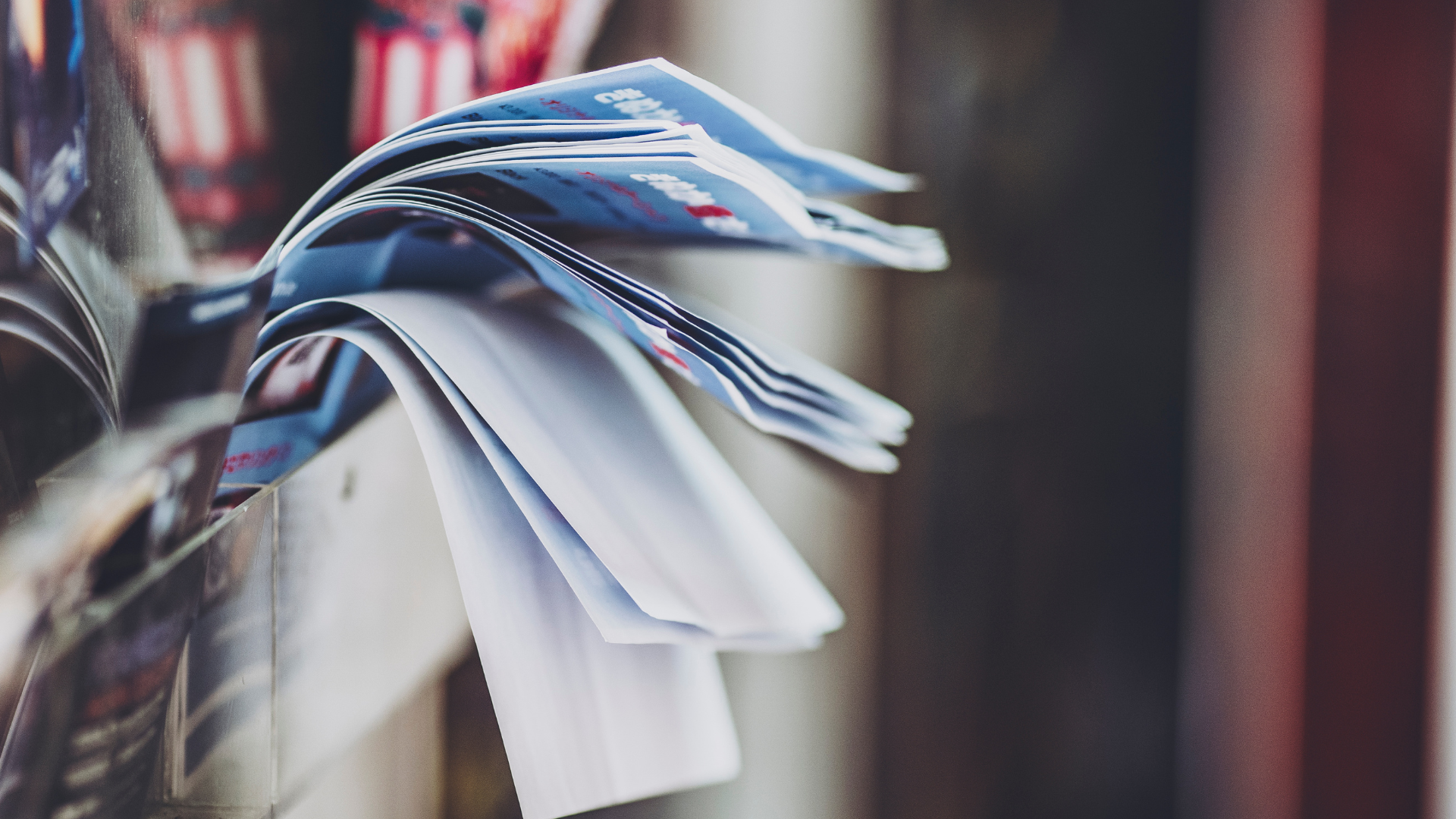 Blue and white paper sheets fanned out from a shelf