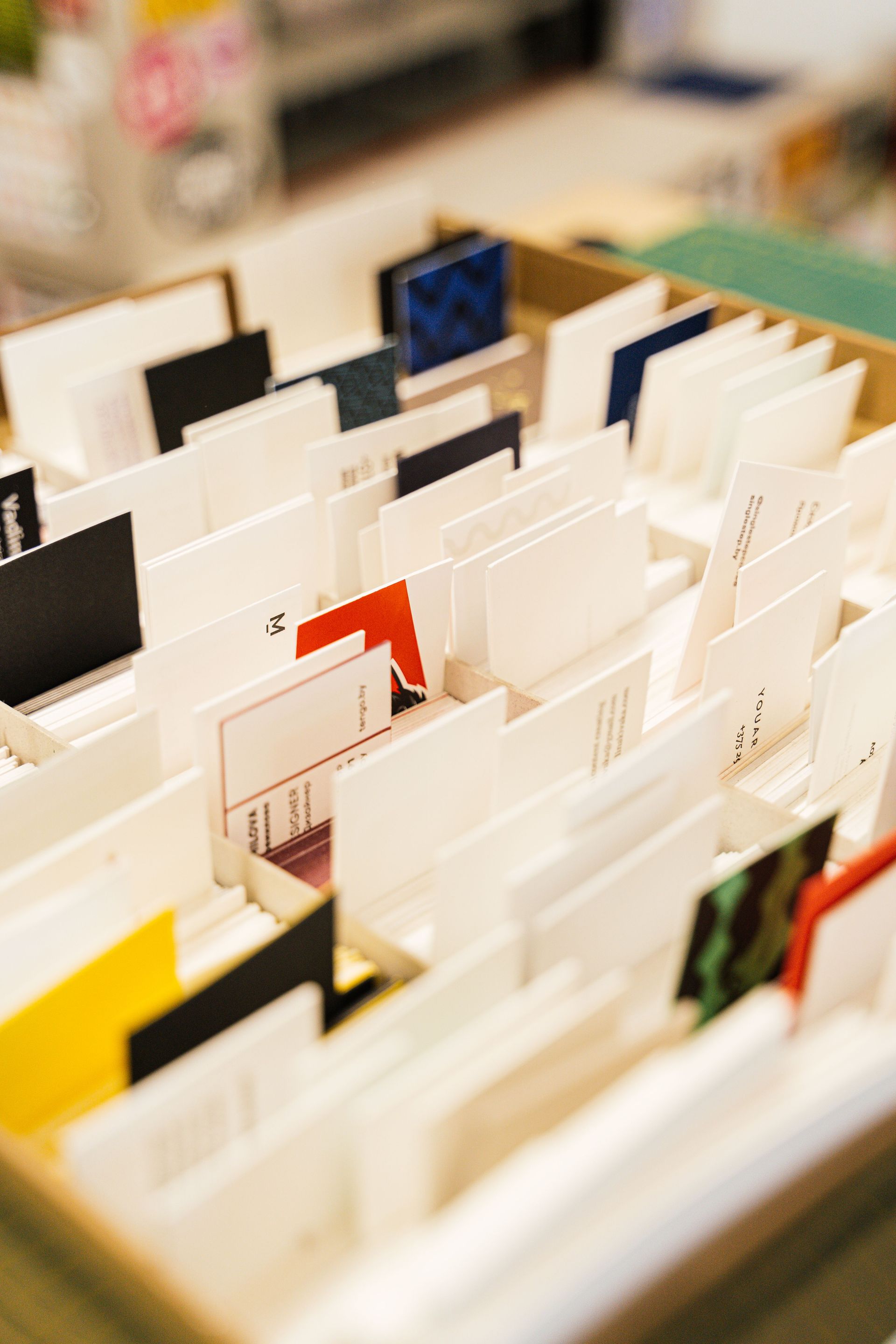 Stack of blue-and-white business cards with geometric pixel design on a gray surface
