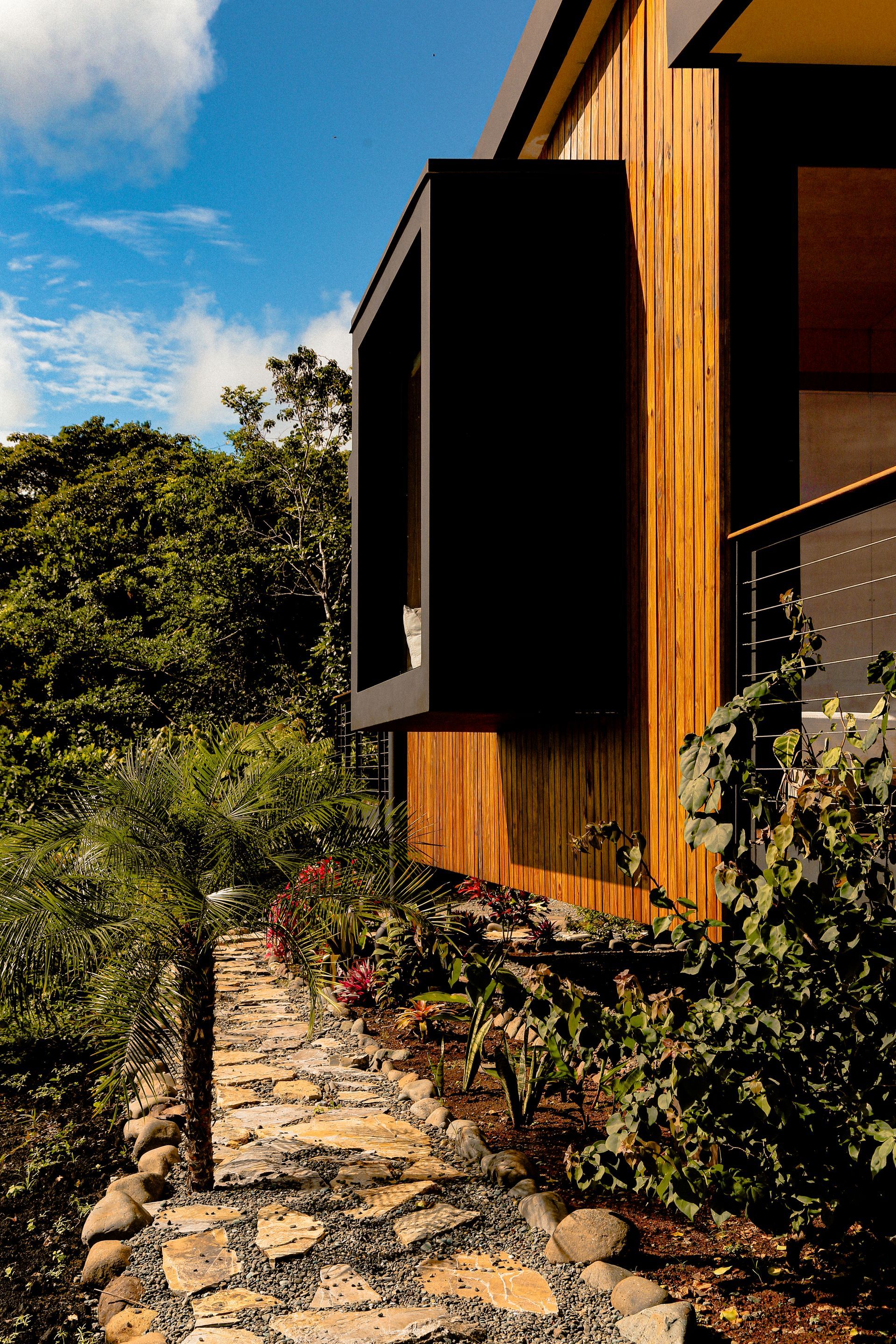 Wooden deck and railing on a porch with forest views and a small “Coral” sign