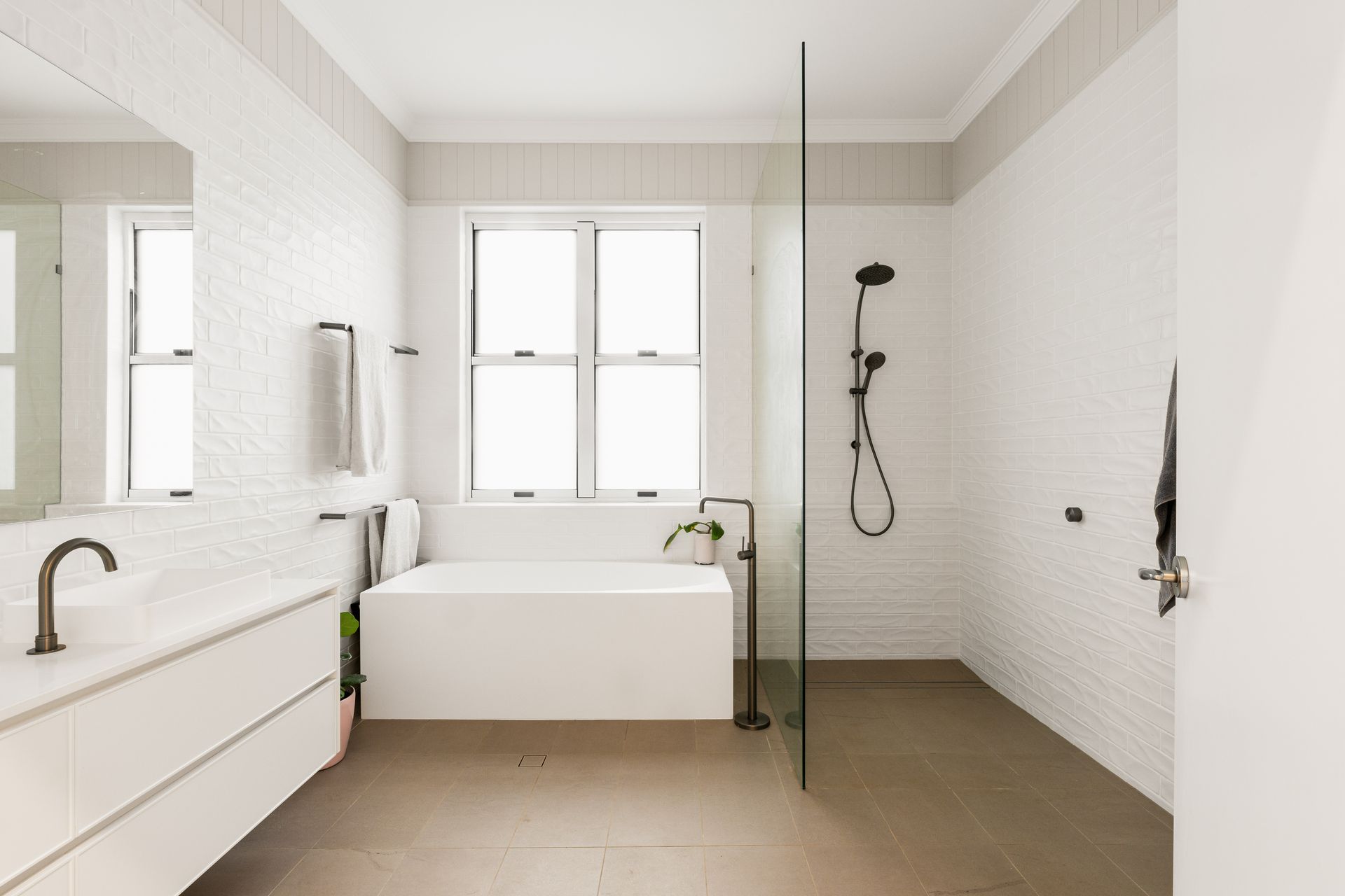 A Bathroom With White Cabinets and Drawers and a Brick Wall — Halls Cabinets & Joinery in Harlaxton, QLD