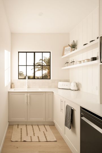 A Kitchen With Large Window and cream cabinets  — Halls Cabinets & Joinery in Harlaxton, QLD