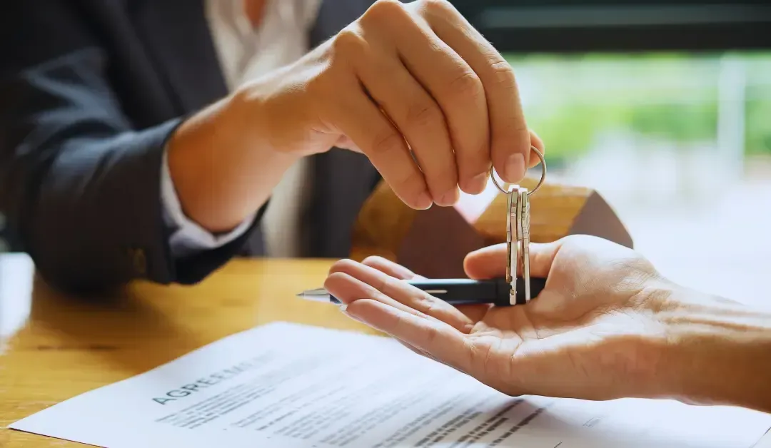 A person is holding a pen and keys in their hand.