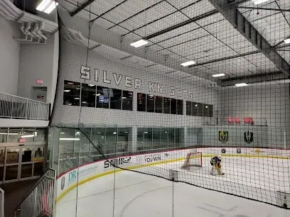 A hockey rink with a net and a sign that says silver knights on the wall.