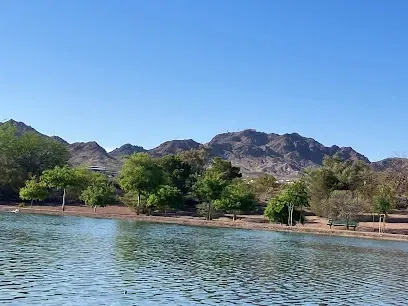 A lake with mountains in the background and trees on the shore