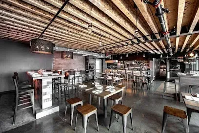 A restaurant with tables and chairs and a wooden ceiling.