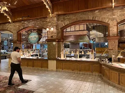 A man is walking through a buffet line in a restaurant.