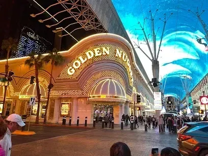 A group of people are standing in front of a building that says golden nugget.