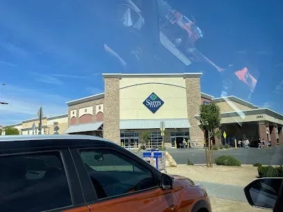 A car is parked in front of a sam 's club store.