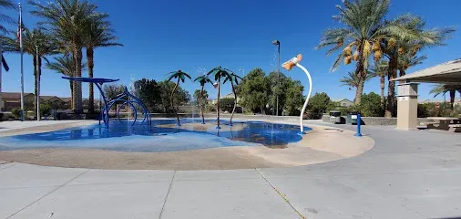 A swimming pool in a park with palm trees in the background.