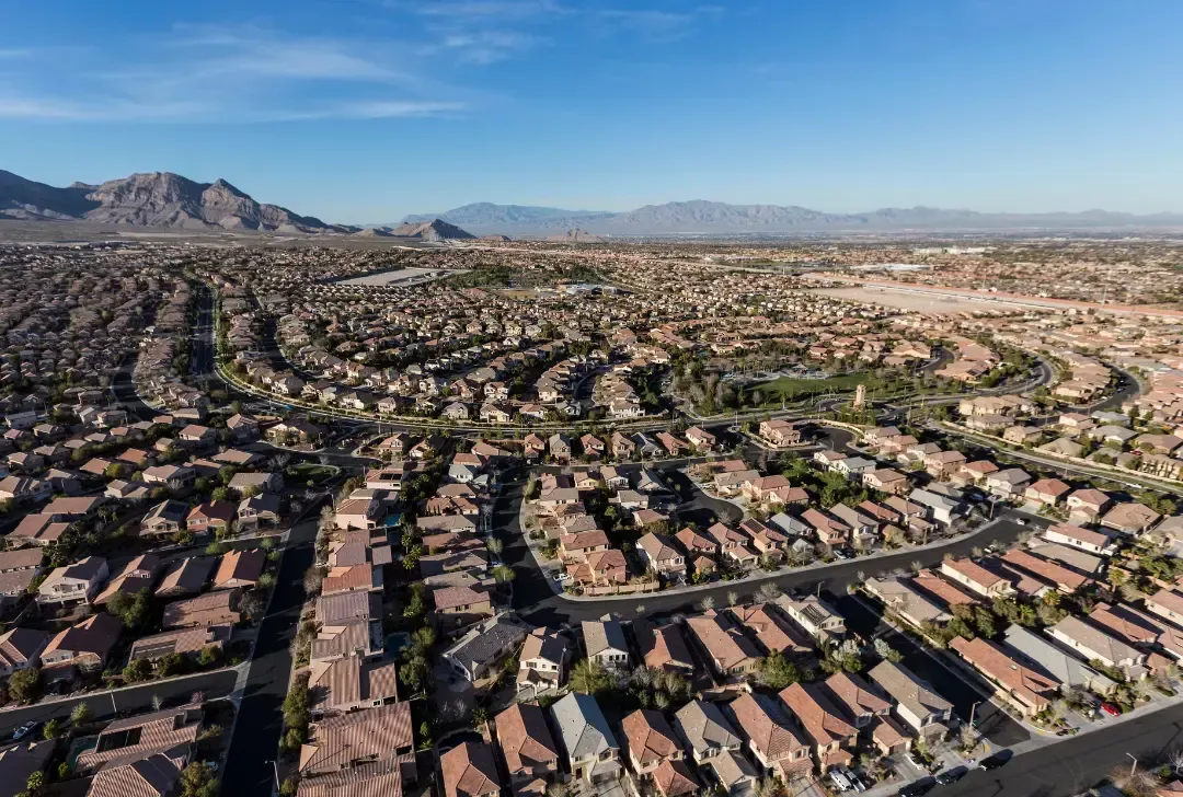 An aerial view of a residential area with mountains in the background.