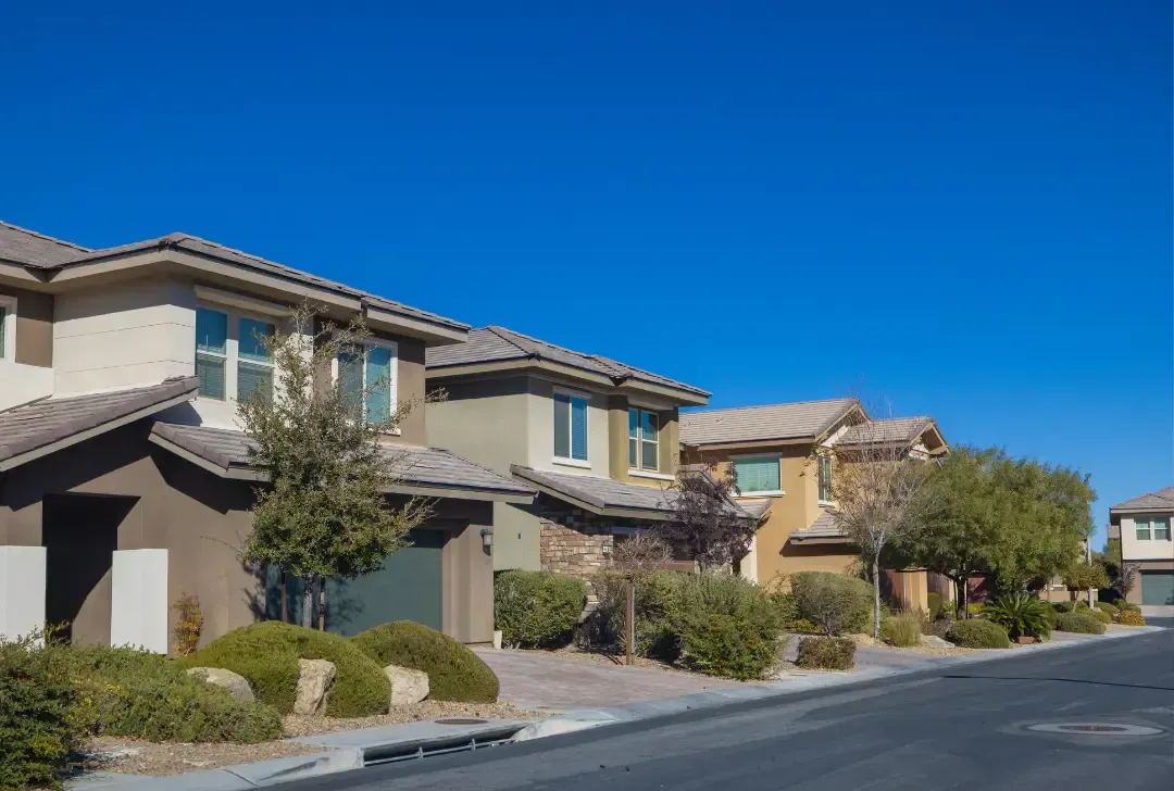 A row of houses are lined up on the side of a street.