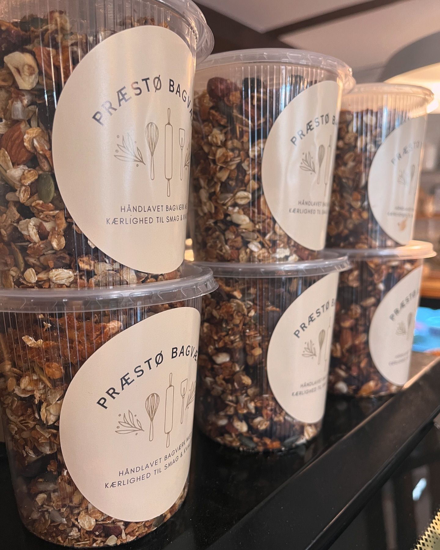 En række beholdere fyldt med granola og nødder.