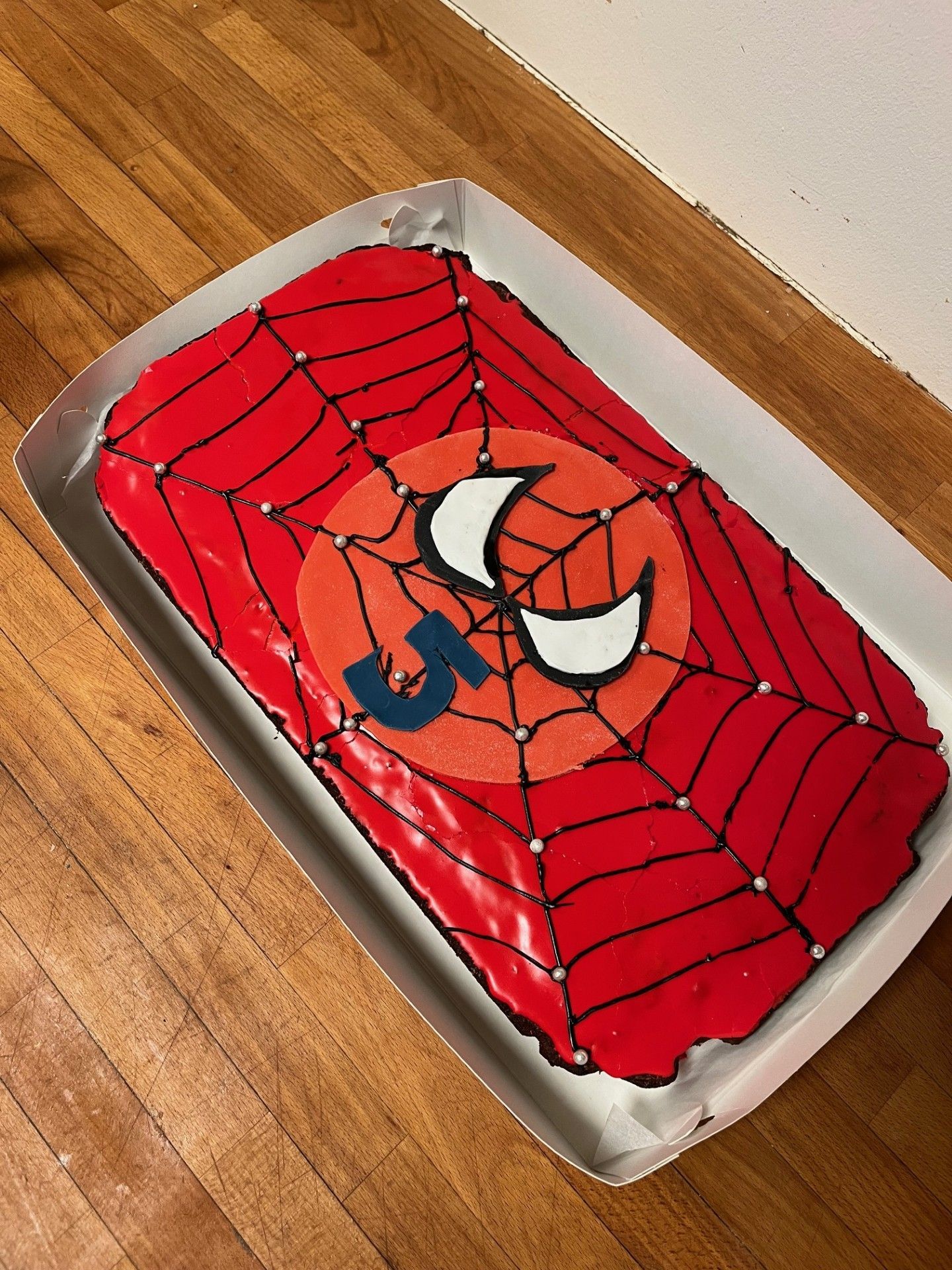 Fødselsdagskage med Spider-Man-tema, rød glasur, et webdesign og et