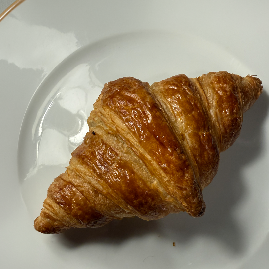 Gyldenbrun croissant på en hvid tallerken