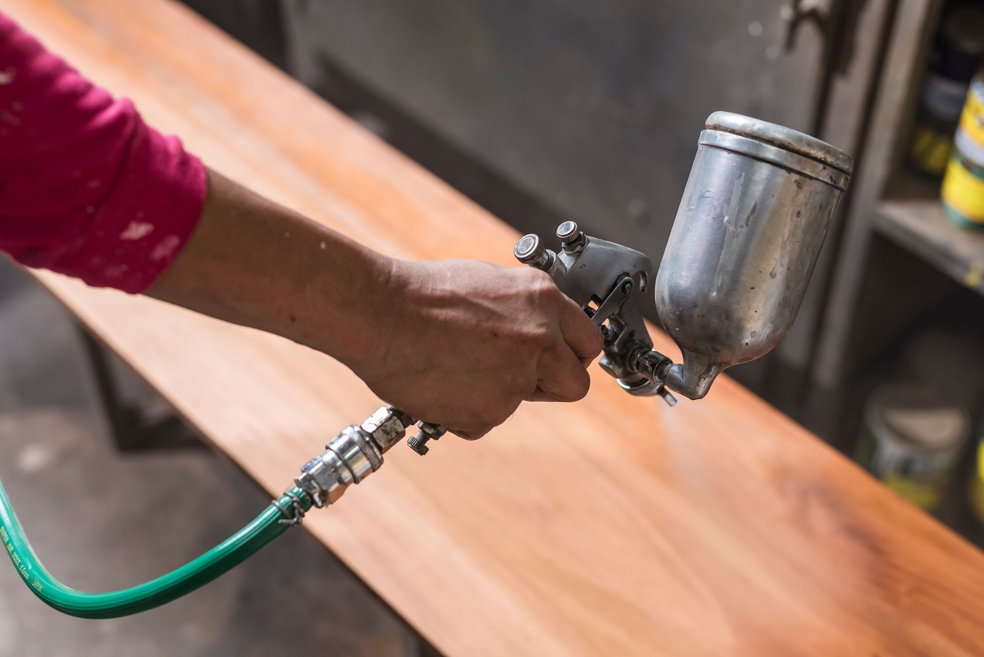 A man is spraying a piece of wood.