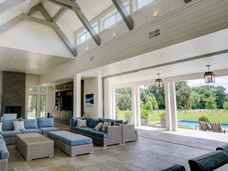 a living room with a lot of furniture and a pool in the background