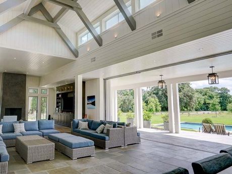 a living room with a lot of furniture and a pool in the background