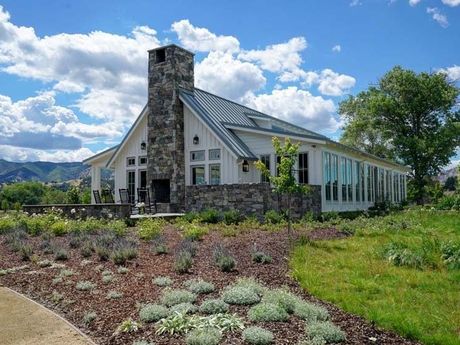 a white house with a metal roof and a stone chimney