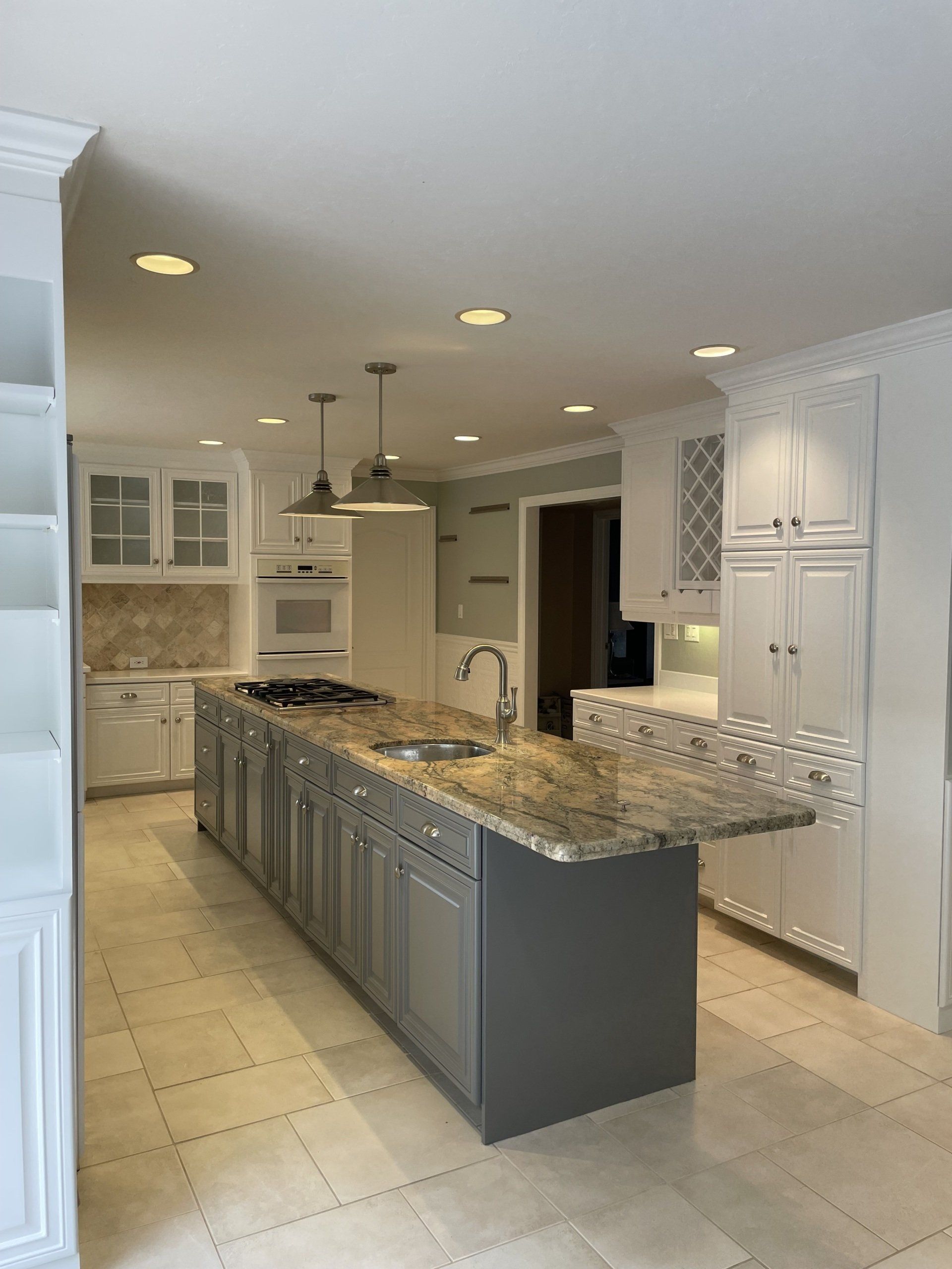 A kitchen with a large island and granite counter tops.