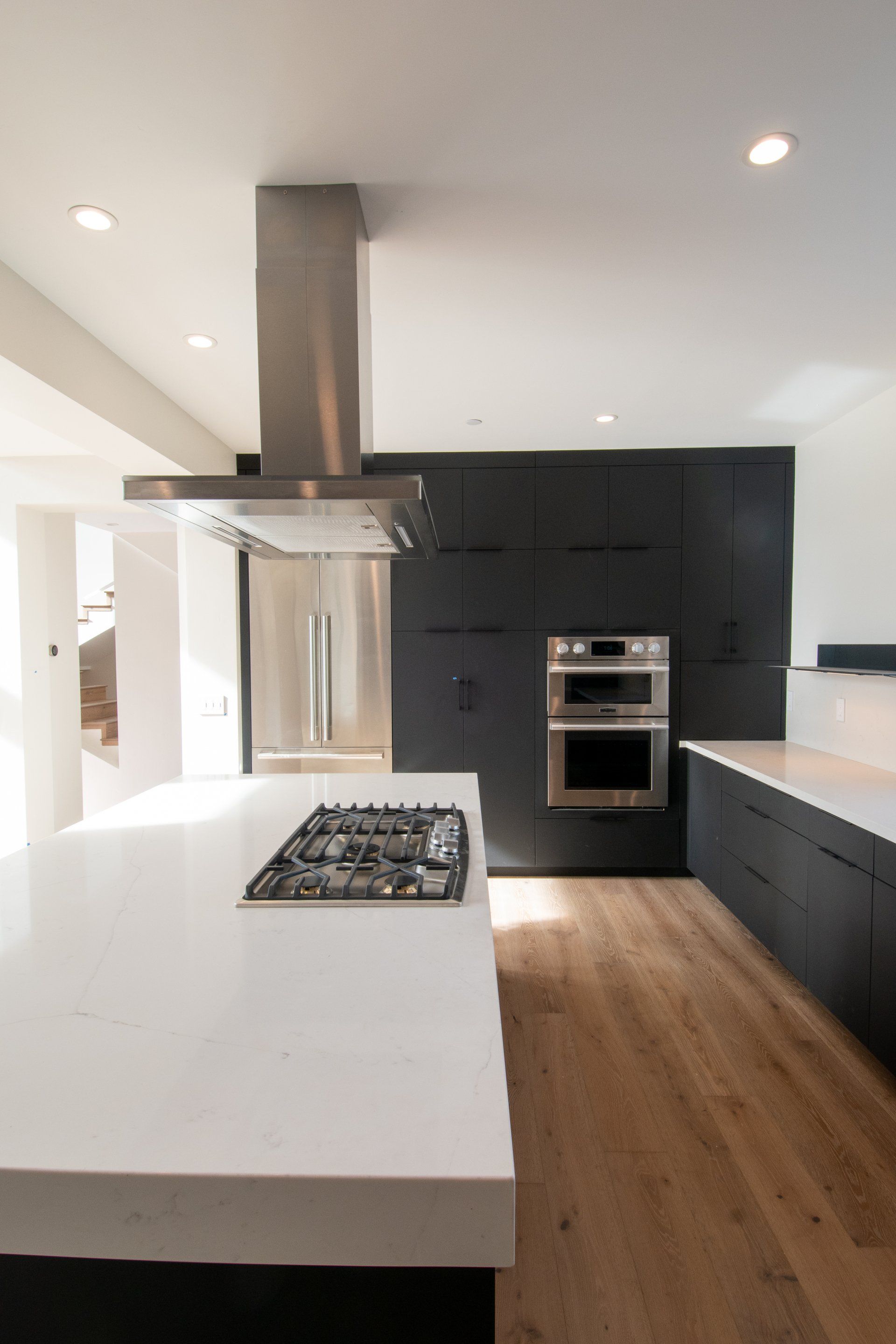 A kitchen with a stove top oven and a refrigerator.