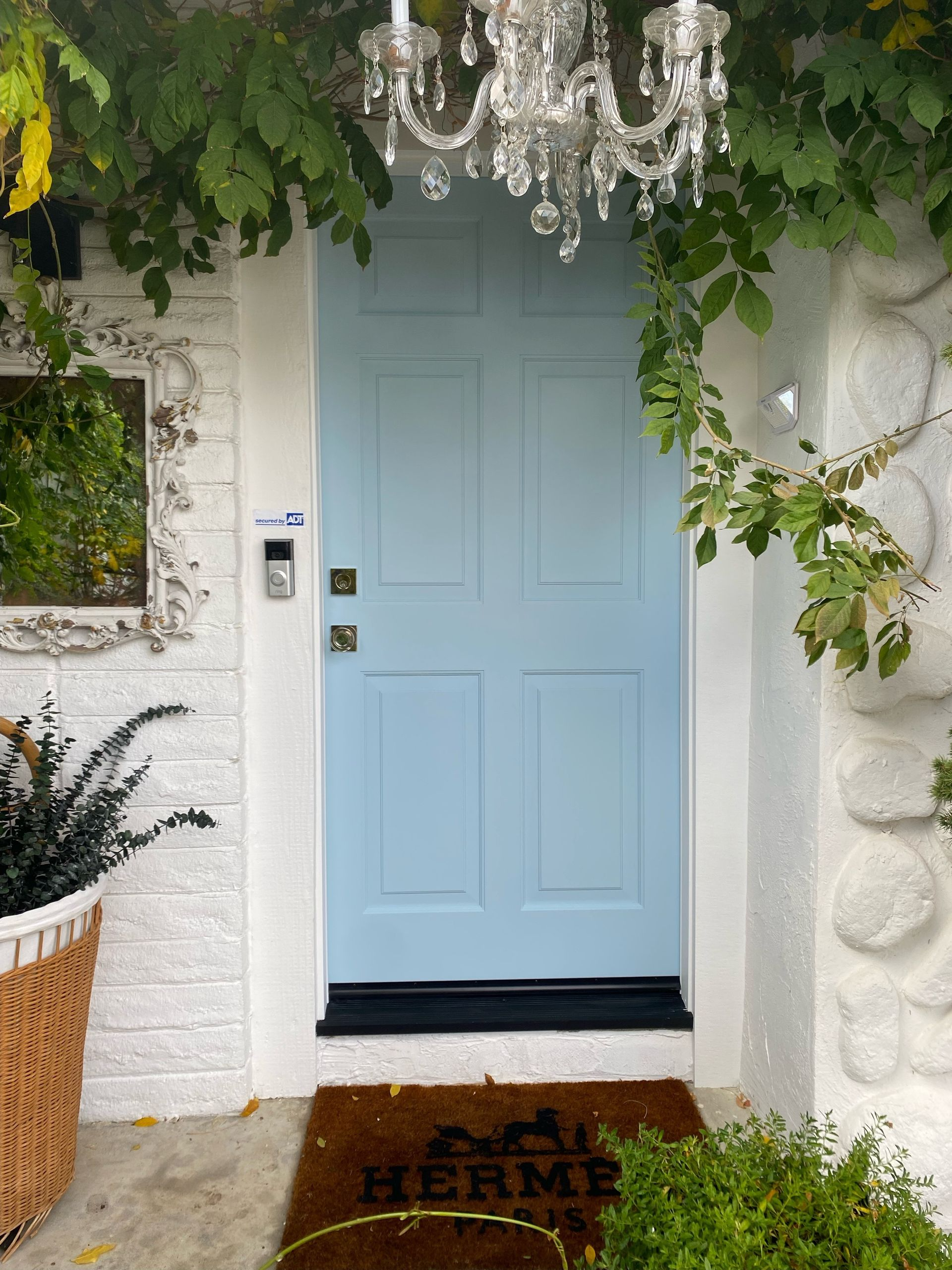 A blue door with a hermes doormat in front of it