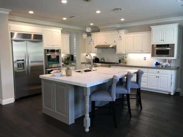 A kitchen with white cabinets and stainless steel appliances