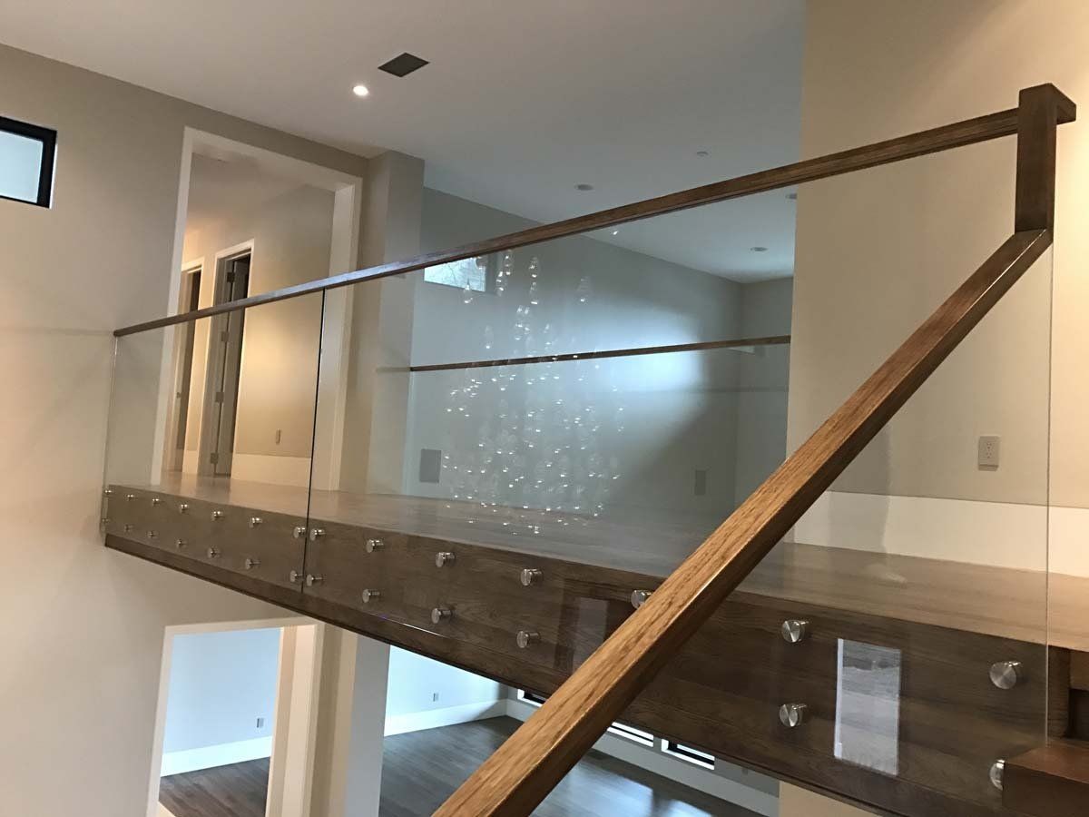 A wooden staircase with a glass railing in a house.