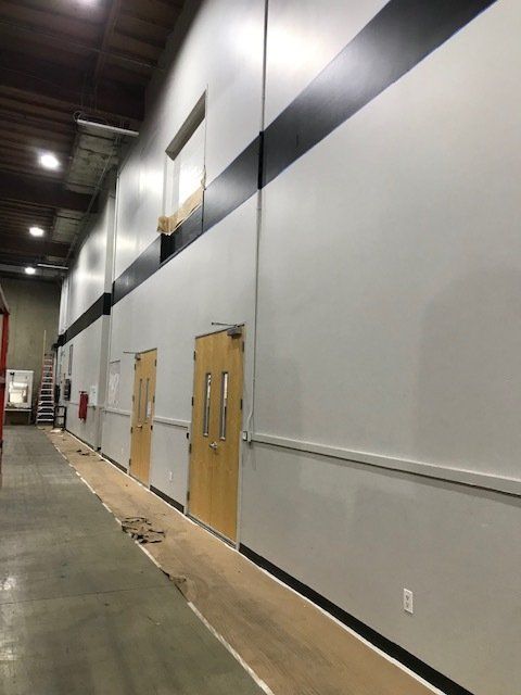 A long hallway with white walls and wooden doors
