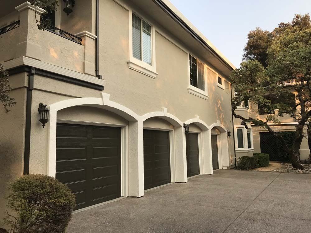 A house with a lot of garage doors and a balcony