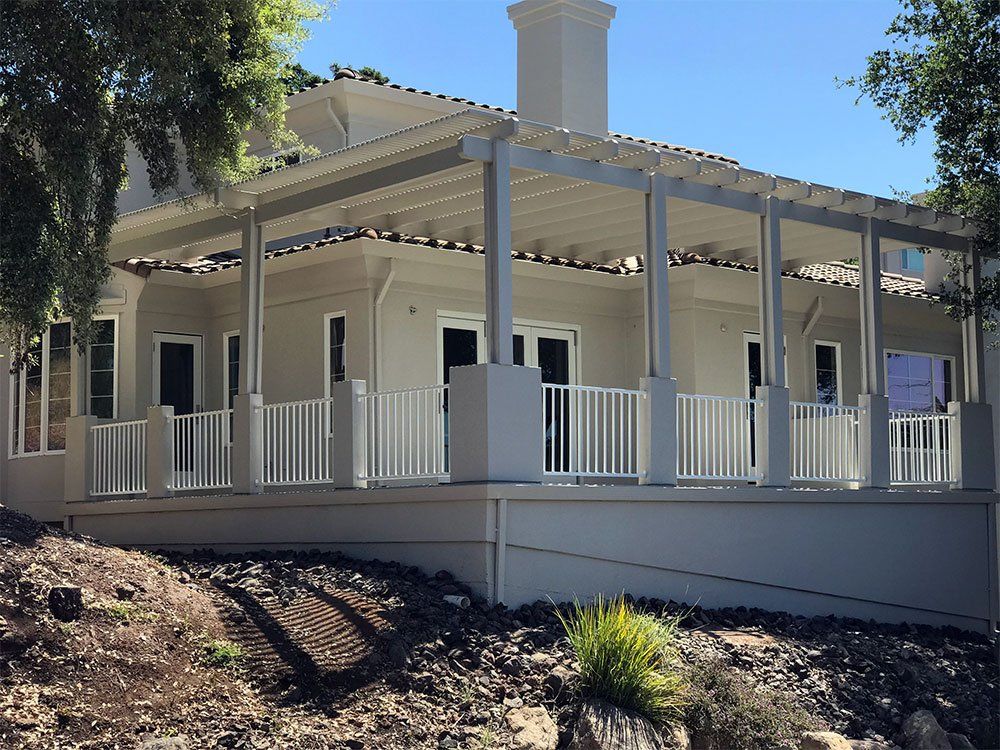 A white house with a large porch and a white railing