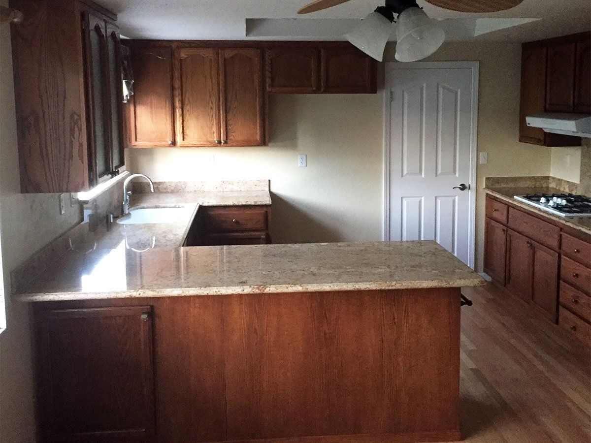 A kitchen with wooden cabinets and granite counter tops