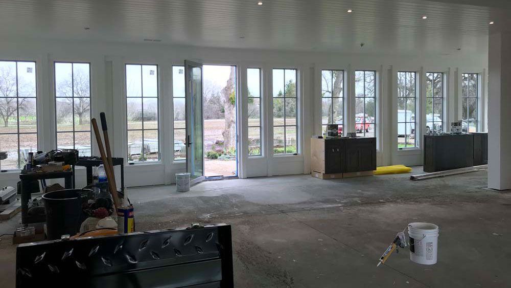 A large room with a lot of windows and a bucket on the floor.