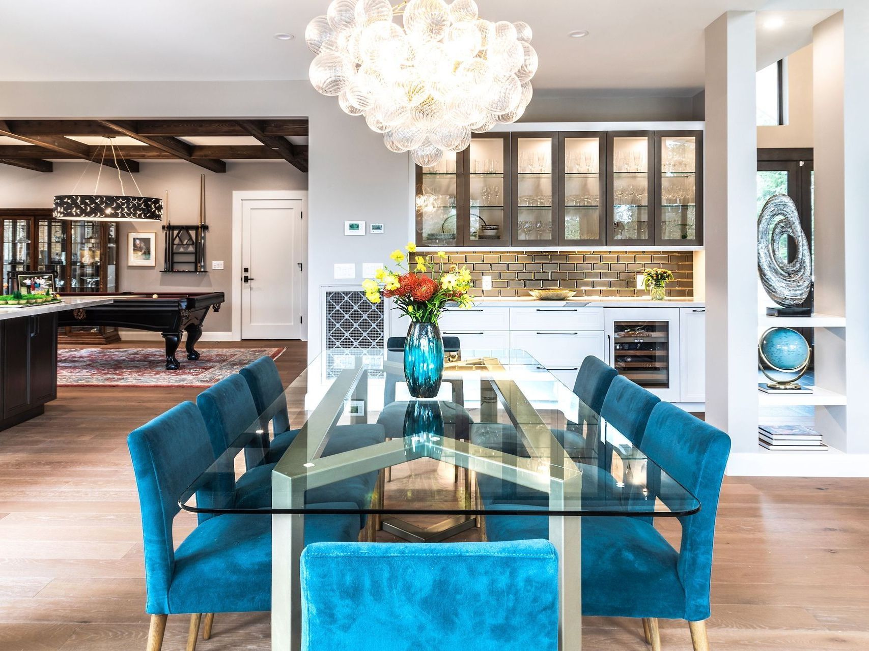 a dining room with a glass table and blue chairs