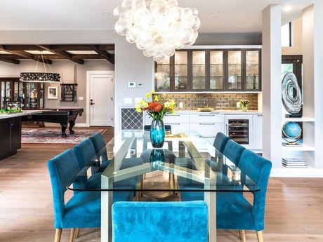 a dining room with a glass table and blue chairs