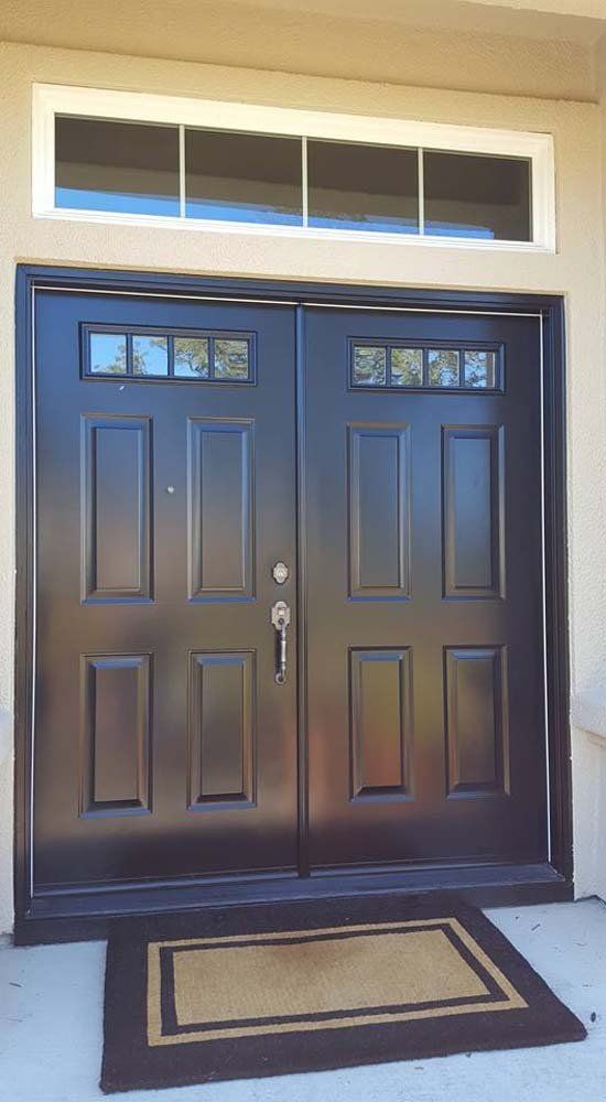 A black double door with a window and a rug in front of it.