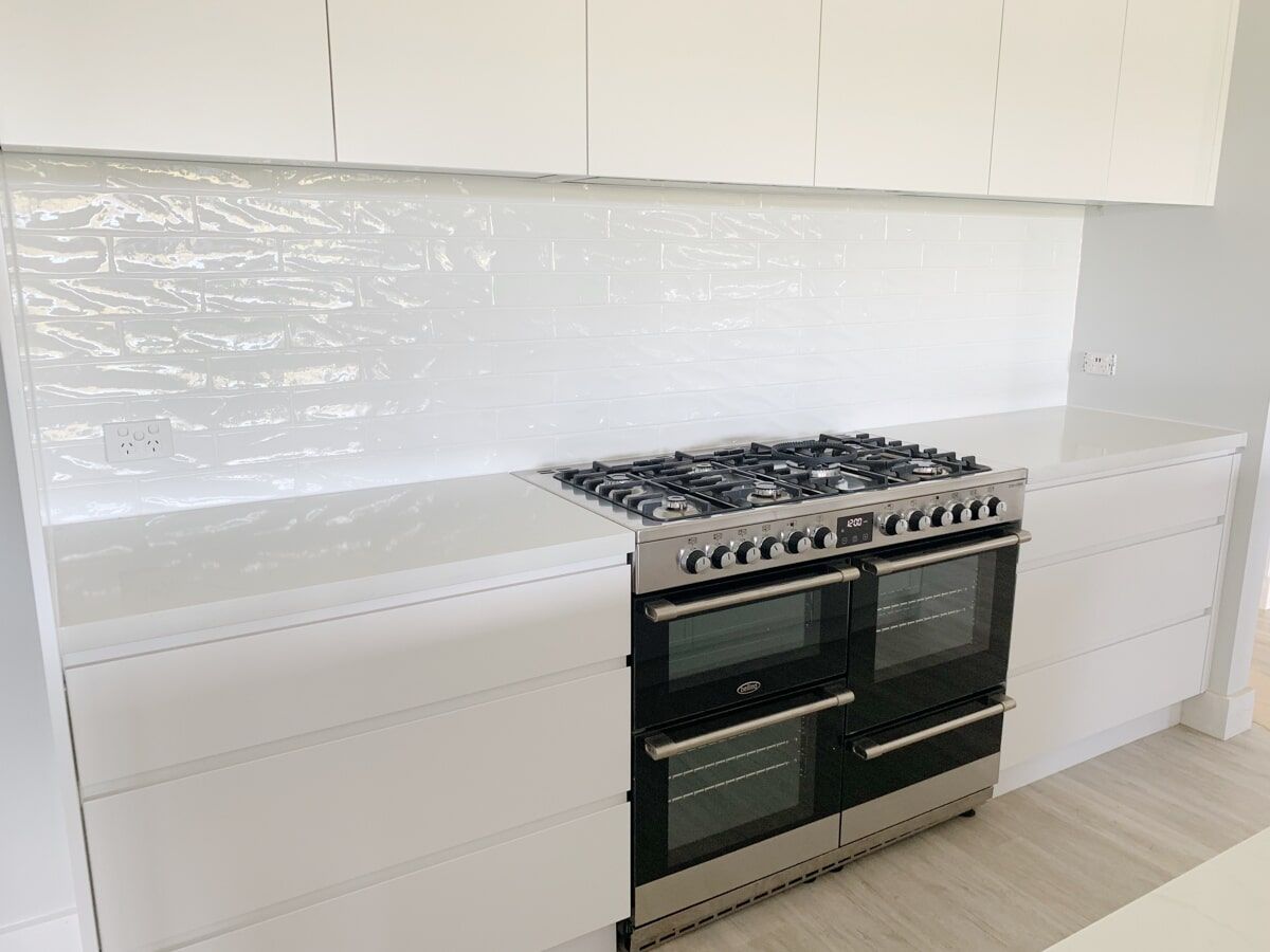 a stove and oven in a kitchen with white cabinets .