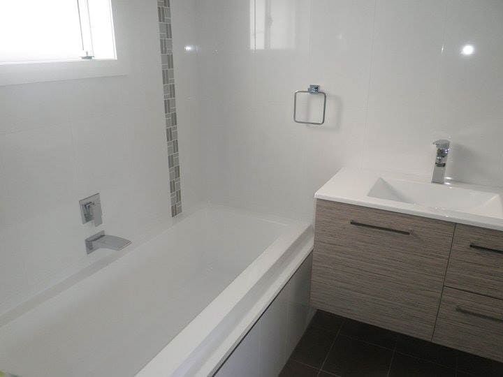 A Bathroom with a Bathtub, sink, and Window — Illawarra Bathrooms in Wollongong, NSW	