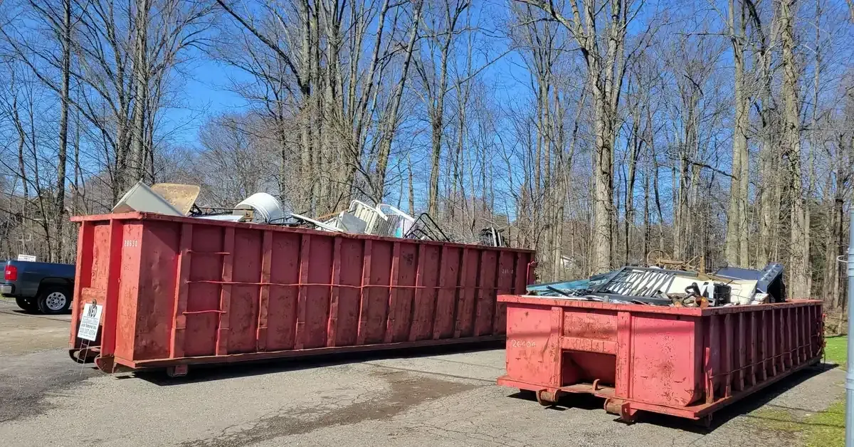Loaded roll-off dumpsters from a Northeast Ohio junk removal job with bare trees in the background