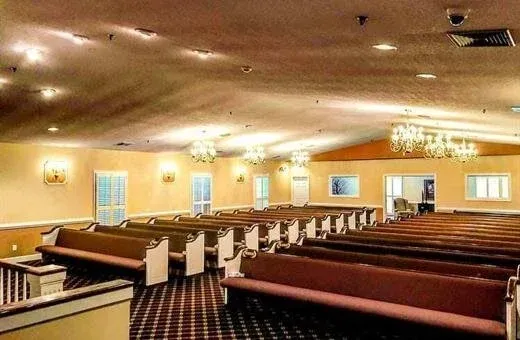 Empty church sanctuary with rows of wooden pews and warm ceiling lights