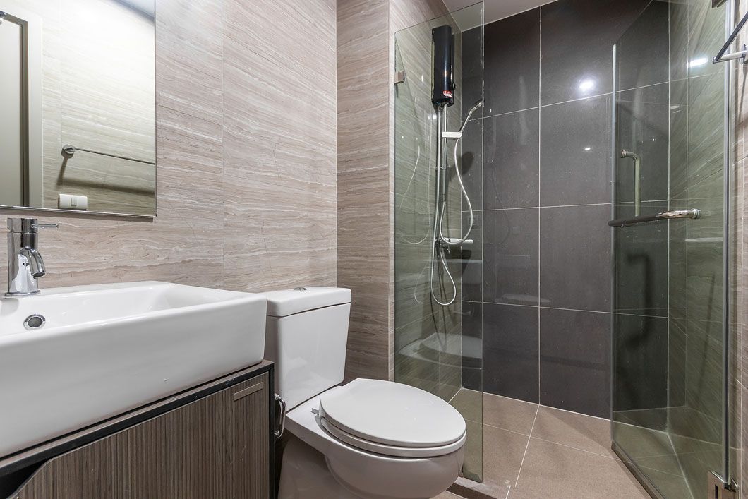 A bathroom with a toilet , sink and walk in shower.