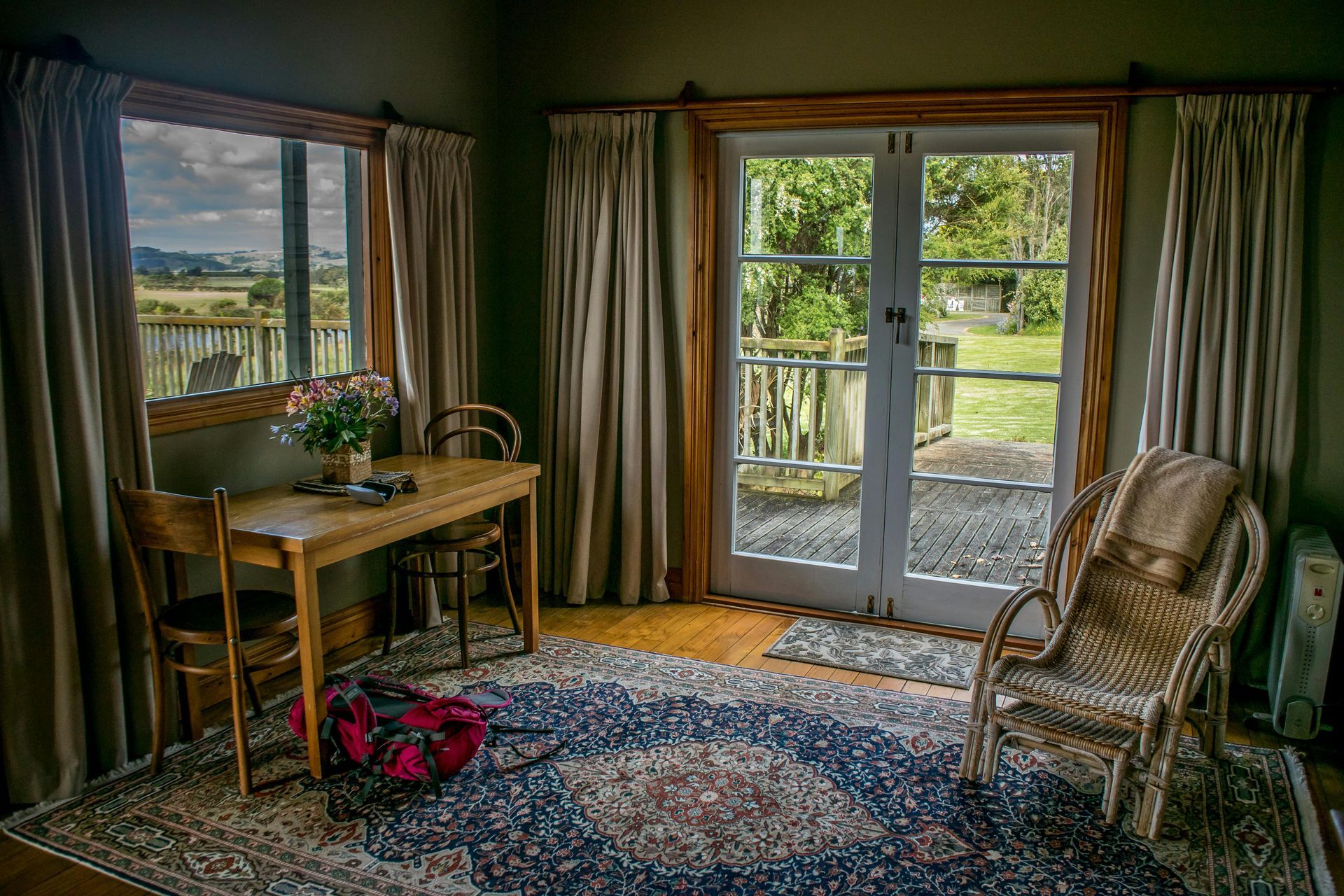 A living room with a table and chairs and a rug.
